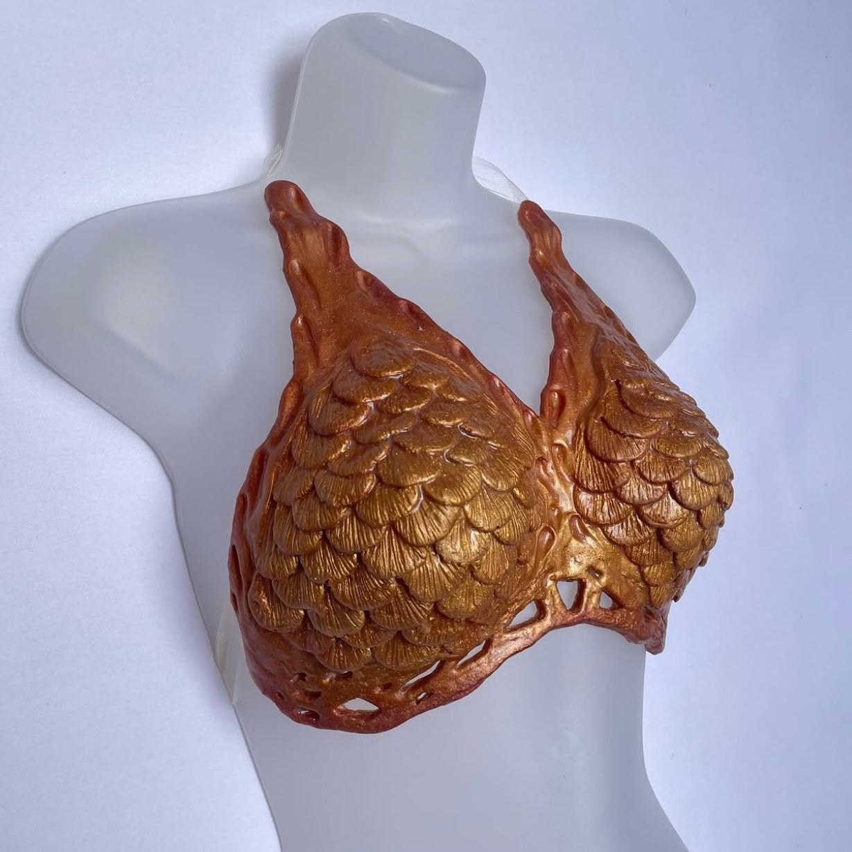 Gold scale-patterned bra on a mannequin against a white background. Handmade Mako mermaid top, swimmable silicone bra with seamless power mesh fit. Silicone mermaid top
